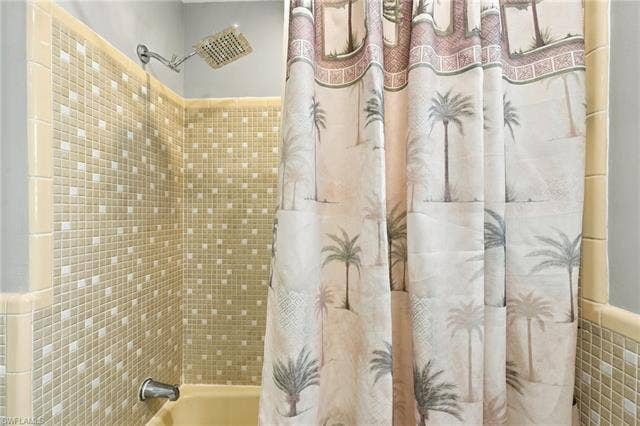 2816 18th Ave, Cape Coral, FL 33904 Shower with mosaic tile surround and a chrome rain showerhead