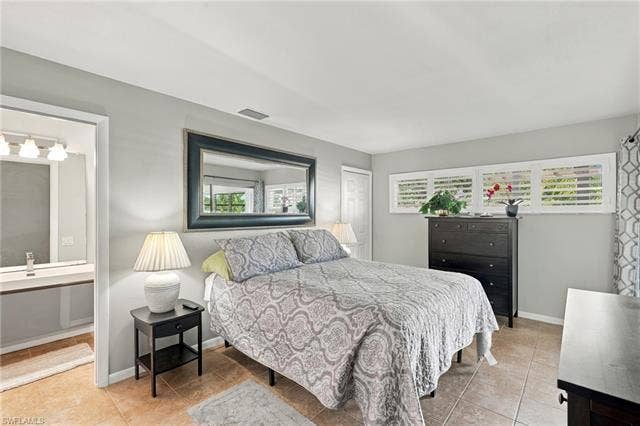 2816 18th Ave, Cape Coral, FL 33904 Neutral wall color, ceramic tile flooring, plantation shutters, and a vanity with an undermount sink