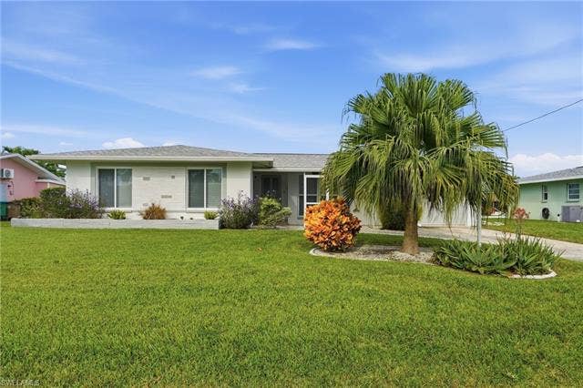 2816 18th Ave, Cape Coral, FL 33904 Front of home with beautiful landscaping and well manicured lawn.