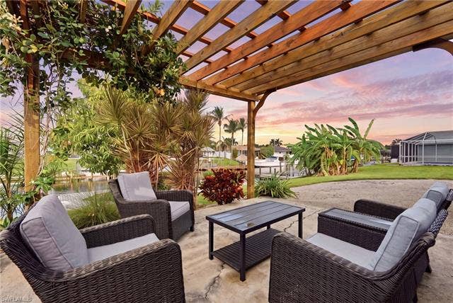 2816 18th Ave, Cape Coral, FL 33904 Outdoor patio with a wooden pergola, lush tropical landscaping, and waterside access