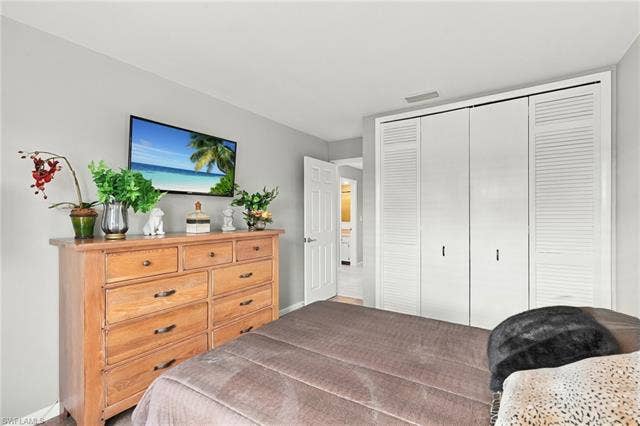 2816 18th Ave, Cape Coral, FL 33904 Recessed lighting, light gray wall finish, white louvered bifold closet doors, white interior door, and wood-finish flooring