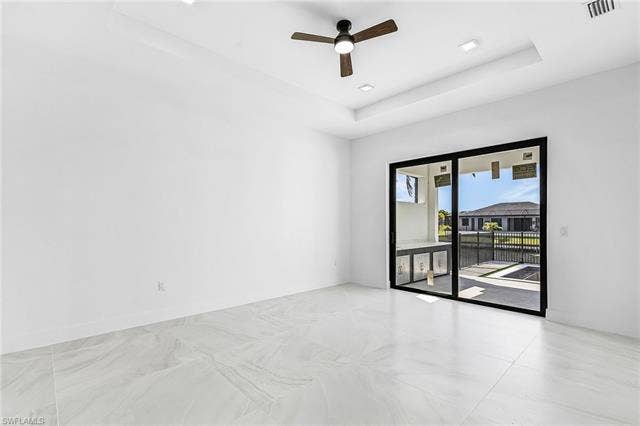 4116 36th Ln, Cape Coral, FL 33993 Expansive room featuring large format floor tiling, a tray ceiling, recessed lighting, and a ceiling fan