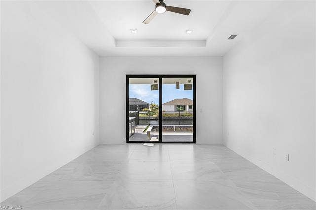 4116 36th Ln, Cape Coral, FL 33993 Recessed lighting, ceiling fan, tray ceiling, sliding glass door, and large format tile flooring