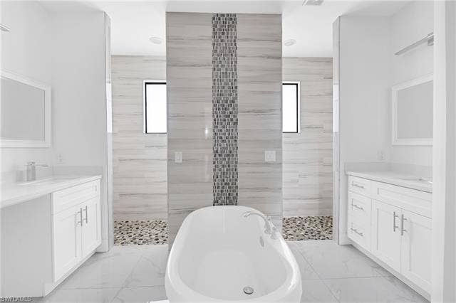 113 38 Pl, Cape Coral, FL 33993 Spa-inspired primary bathroom featuring a freestanding soaking tub, dual vanities with white cabinetry and quartz countertops, large-format tile flooring, a walk-in shower with linear mosaic accent strip and pebble floor detail, and dual window placement for natural light
