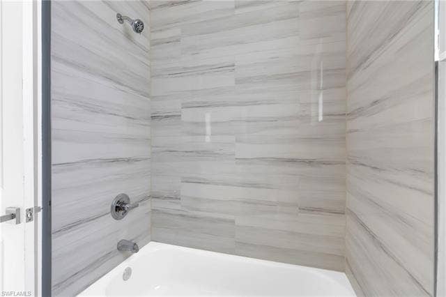 113 38 Pl, Cape Coral, FL 33993 Bathtub with polished chrome fixtures and light-toned, horizontally laid wall tiling