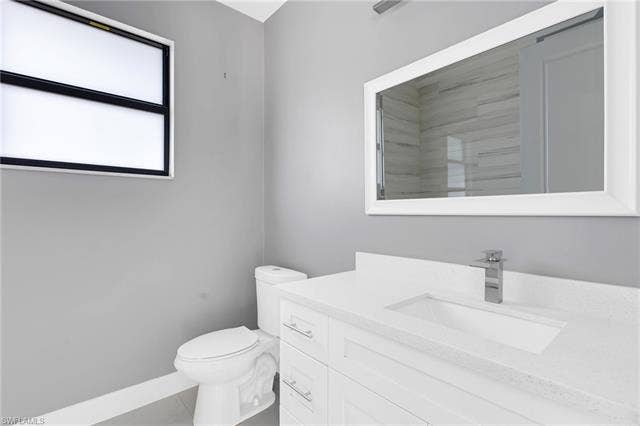 113 38 Pl, Cape Coral, FL 33993 White vanity with an integrated sink, polished chrome faucet, and a framed mirror