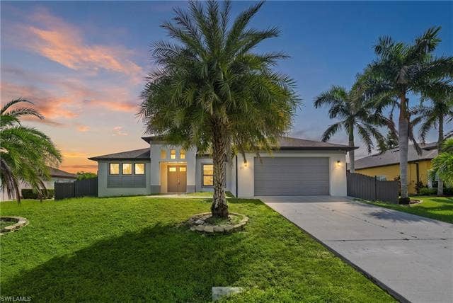 113 38 Pl, Cape Coral, FL 33993 Contemporary exterior with a double-door entry, a two-car garage, and a concrete driveway
