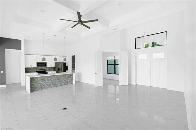 113 38 Pl, Cape Coral, FL 33993 Spacious open-concept interior featuring light tile flooring and high vaulted ceilings