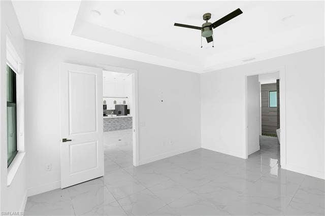 113 38 Pl, Cape Coral, FL 33993 Recessed ceiling with an integrated ceiling fan, large format tile flooring, and a window with dark trim