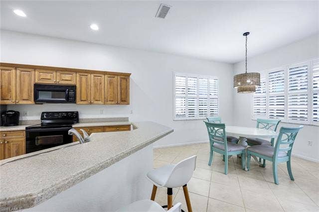 9375 Oak Strand Dr, Estero, FL 34135 Kitchen featuring visible vents, light countertops, black appliances, a sink, and light tile patterned flooring