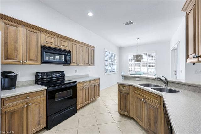 9375 Oak Strand Dr, Estero, FL 34135 Kitchen featuring light tile patterned floors, visible vents, hanging light fixtures, light countertops, and black appliances