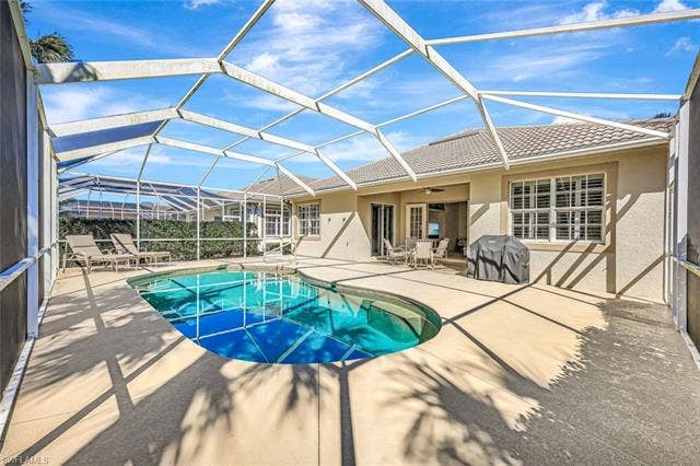 9375 Oak Strand Dr, Estero, FL 34135 Pool with a ceiling fan, glass enclosure, a patio, and grilling area