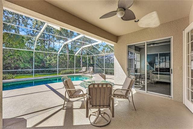 9375 Oak Strand Dr, Estero, FL 34135 View of patio / terrace featuring a lanai, a ceiling fan, and an outdoor pool