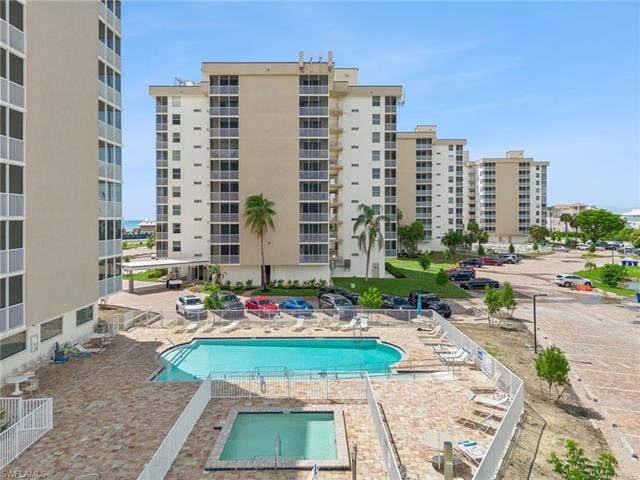 5500 Bonita Beach Rd, #308, Bonita Springs, FL 34134 Outdoor swimming pool with surrounding paver decking, adjacent spa, and multiple residential towers
