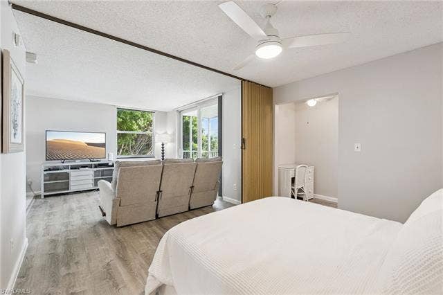 5500 Bonita Beach Rd, #308, Bonita Springs, FL 34134 Wood-finish flooring, ceiling fan, and large windows with natural light