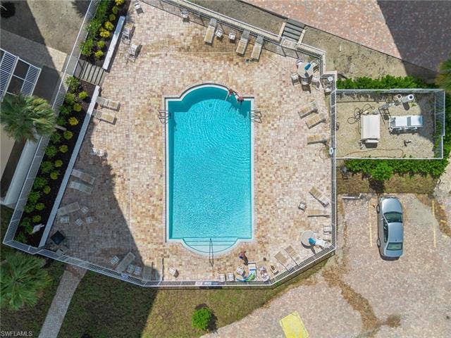 5500 Bonita Beach Rd, #308, Bonita Springs, FL 34134 Second Rectangular swimming pool with curved entry steps, surrounded by paver decking, and fenced perimeter