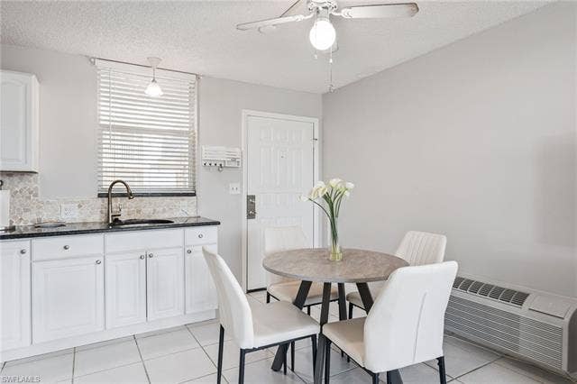 5500 Bonita Beach Rd, #308, Bonita Springs, FL 34134 White cabinetry with dark granite countertops, tiled backsplash, and a stainless-steel sink with a gooseneck faucet