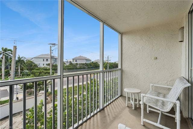 5500 Bonita Beach Rd, #308, Bonita Springs, FL 34134 Screened balcony with textured exterior walls and a metal railing