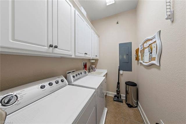 26485 Lucky Stone Rd, #202, Bonita Springs, FL 34135 Laundry area featuring upper cabinetry, a utility sink, and tile flooring