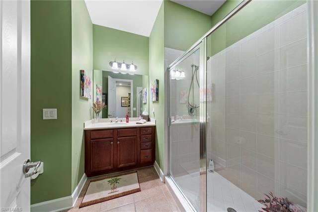 26485 Lucky Stone Rd, #202, Bonita Springs, FL 34135 Enclosed shower with tiled walls, single vanity with wood-finish cabinetry, light-toned countertop, and tile flooring