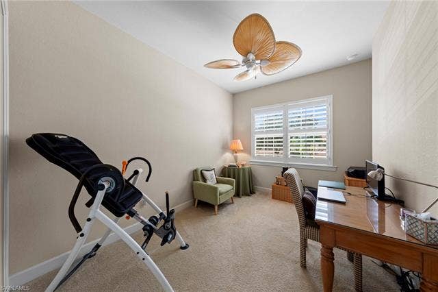26485 Lucky Stone Rd, #202, Bonita Springs, FL 34135 Carpeted room featuring a ceiling fan with decorative blades, windows with plantation shutters, and light-toned wall finishes