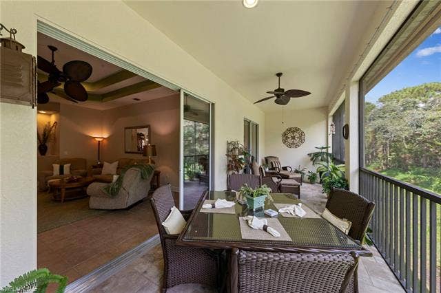 26485 Lucky Stone Rd, #202, Bonita Springs, FL 34135 Screened-in balcony with tile flooring, ceiling fans, and a metal railing