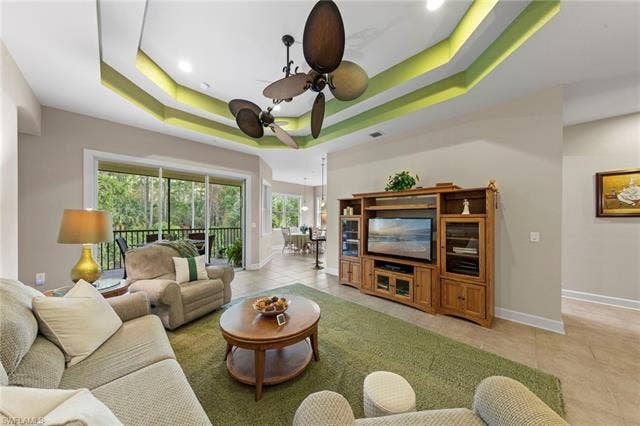 26485 Lucky Stone Rd, #202, Bonita Springs, FL 34135 Coffered ceiling with integrated lighting, multiple ceiling fans, sliding glass door, tiled flooring, and a built-in entertainment center