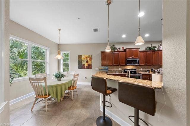 26485 Lucky Stone Rd, #202, Bonita Springs, FL 34135 Kitchen featuring wood-finish cabinetry, granite countertops, and stainless steel appliances