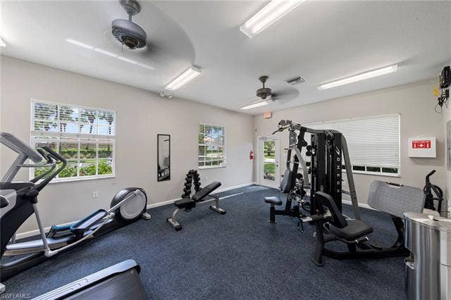 26485 Lucky Stone Rd, #202, Bonita Springs, FL 34135 Fitness area featuring dark blue carpeting, multiple windows, and recessed lighting
