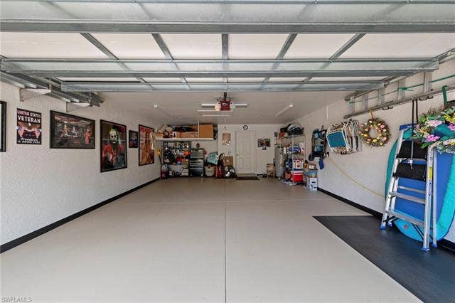 26485 Lucky Stone Rd, #202, Bonita Springs, FL 34135 Epoxy-coated flooring with accent border, overhead garage door track system, and a side entry door