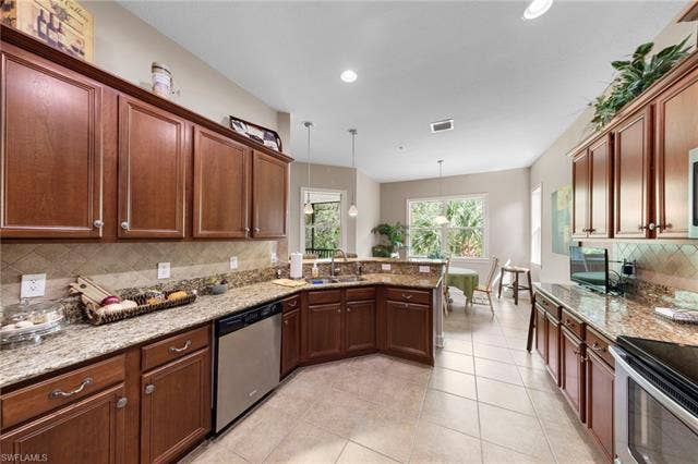 26485 Lucky Stone Rd, #202, Bonita Springs, FL 34135 Kitchen featuring wood cabinetry, light-toned countertops, a stainless steel dishwasher, a built-in oven, and recessed lighting