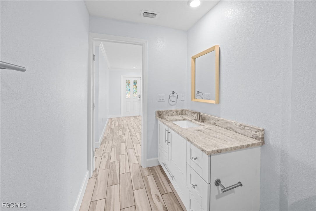 2514 SE 26th Avenue, Cape Coral, FL 33904 Bathroom with wood finish floors, a textured wall, vanity, and recessed lighting