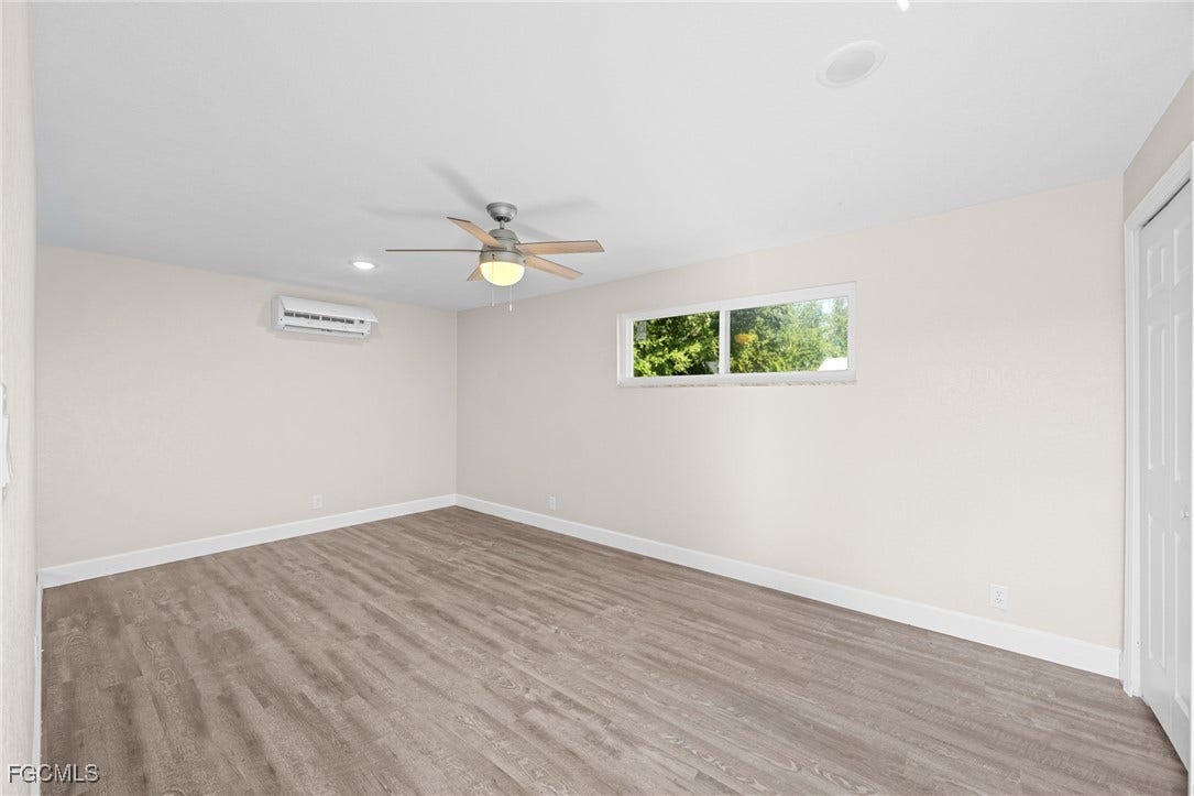 2514 SE 26th Avenue, Cape Coral, FL 33904 Unfurnished bedroom with light wood finished floors, ceiling fan, a closet, recessed lighting, and an AC wall unit
