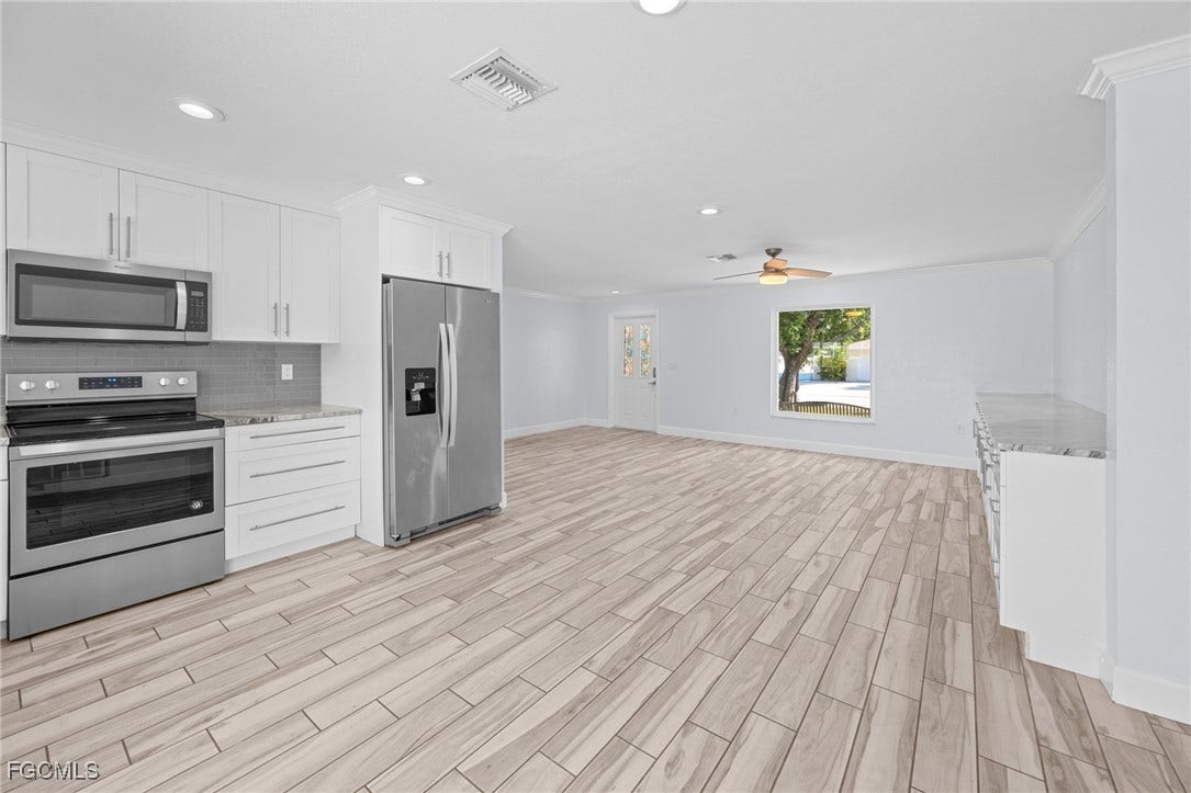 2514 SE 26th Avenue, Cape Coral, FL 33904 Kitchen with appliances with stainless steel finishes, open floor plan, white cabinets, tasteful backsplash, and recessed lighting