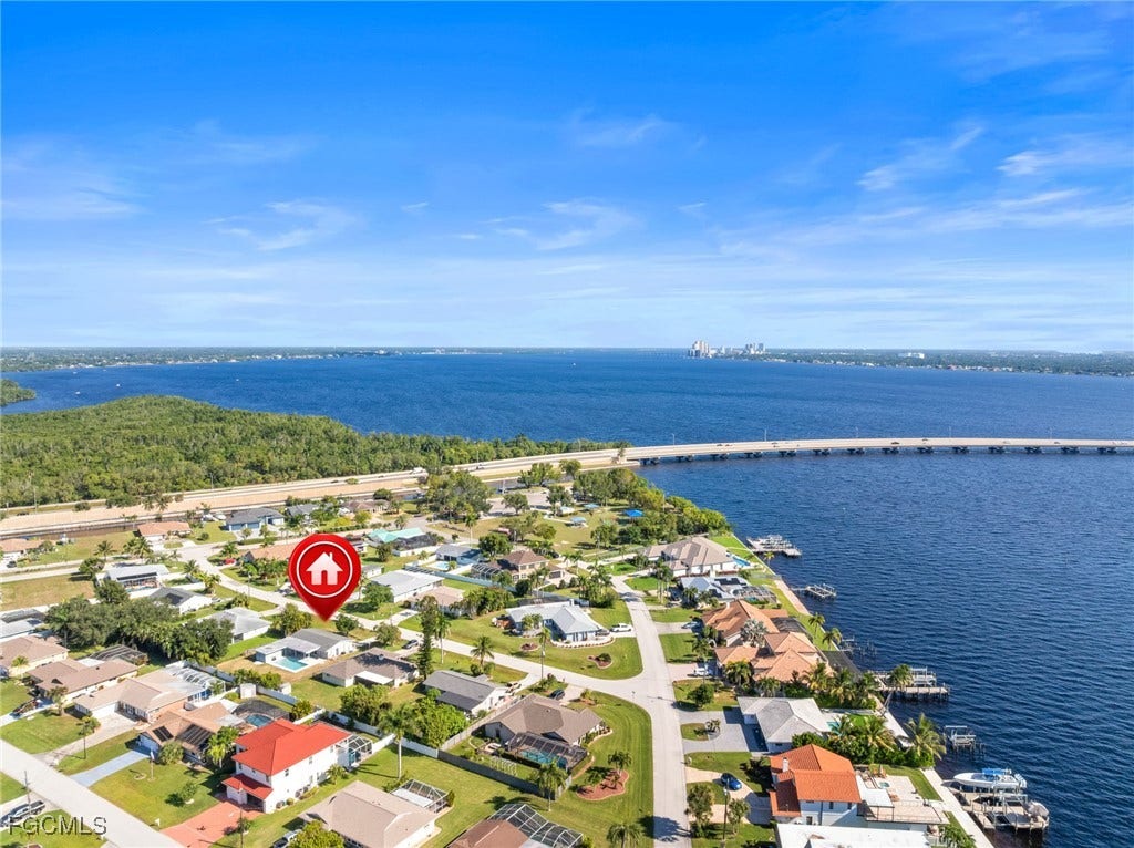 2514 SE 26th Avenue, Cape Coral, FL 33904 Aerial perspective of suburban area with a notable bridge and a nearby body of water