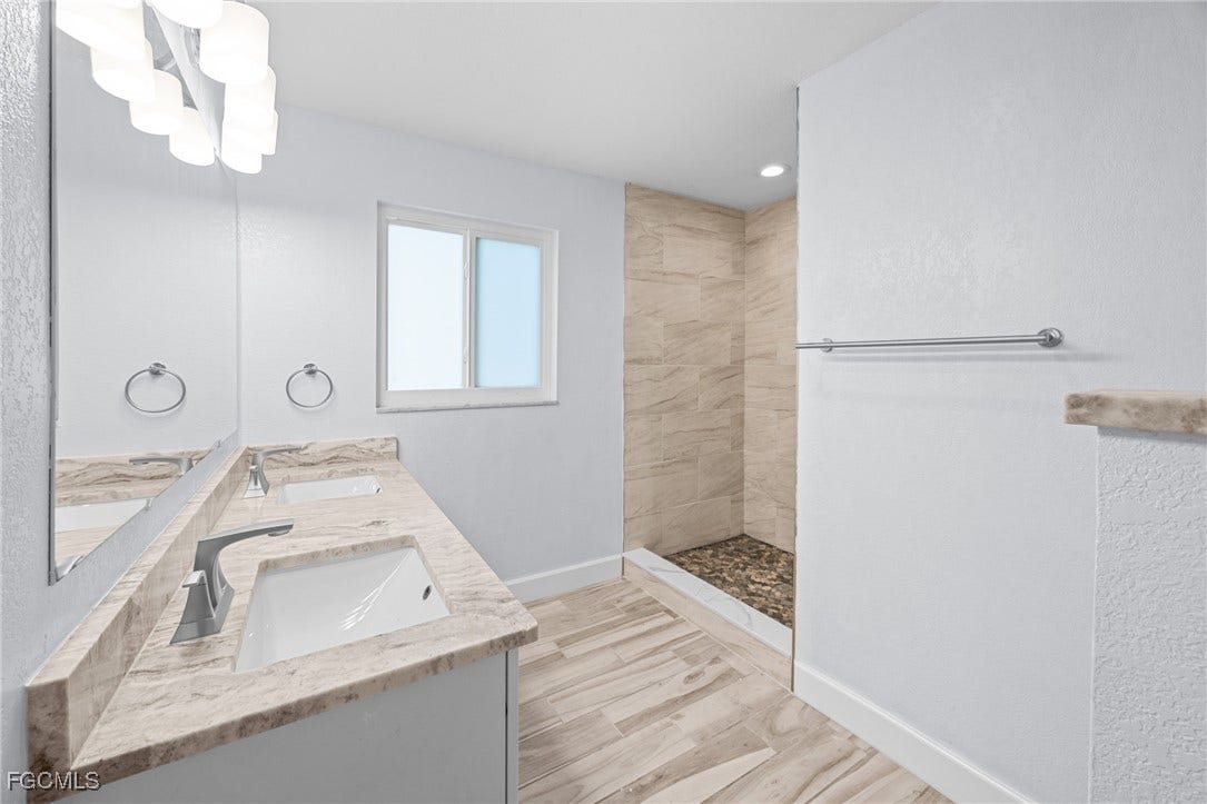2514 SE 26th Avenue, Cape Coral, FL 33904 Full bath featuring double vanity, light wood finished floors, a walk in shower, a chandelier, and recessed lighting