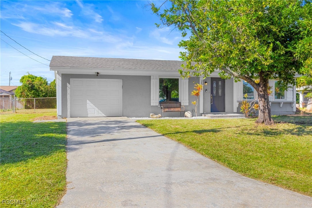 2514 SE 26th Avenue, Cape Coral, FL 33904 Ranch-style house featuring driveway, an attached garage, roof with shingles, and stucco siding