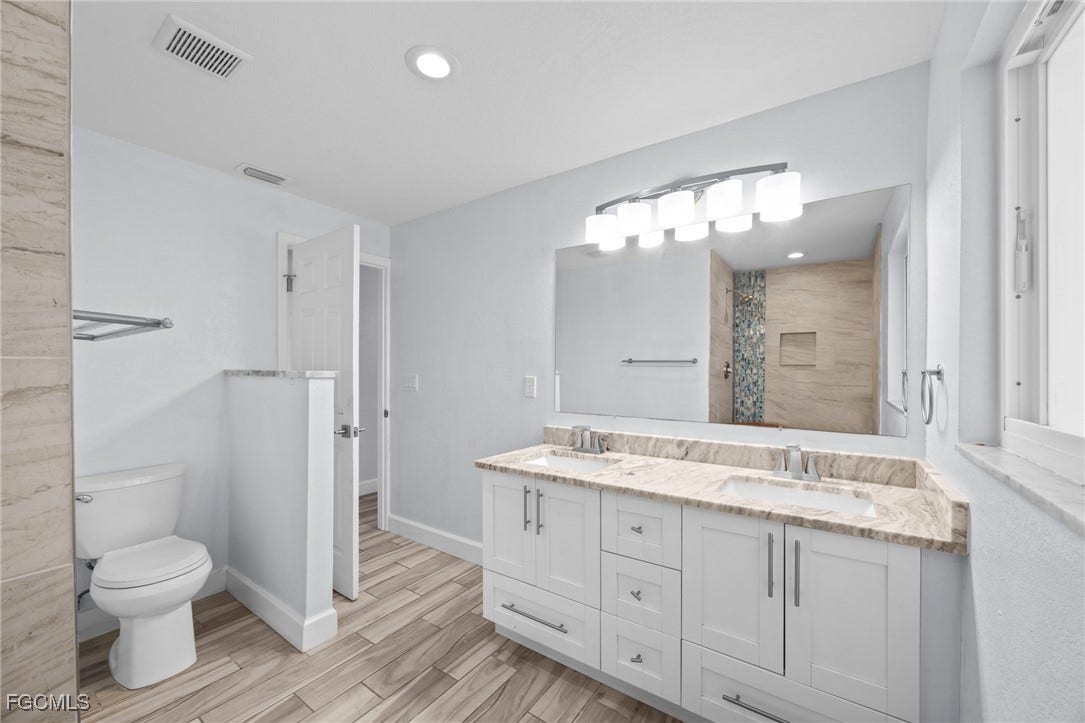 2514 SE 26th Avenue, Cape Coral, FL 33904 Bathroom featuring double vanity, wood finish floors, a shower with curtain, and recessed lighting