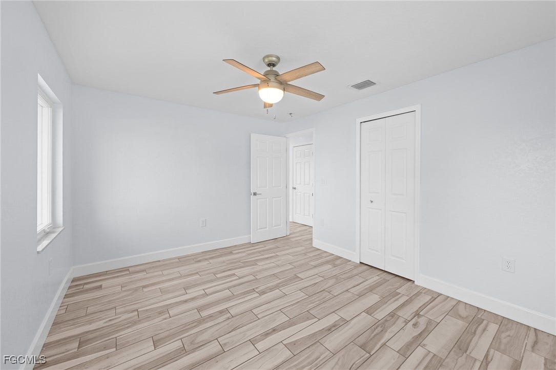 2514 SE 26th Avenue, Cape Coral, FL 33904 Unfurnished bedroom with wood finish floors, a ceiling fan, and a closet