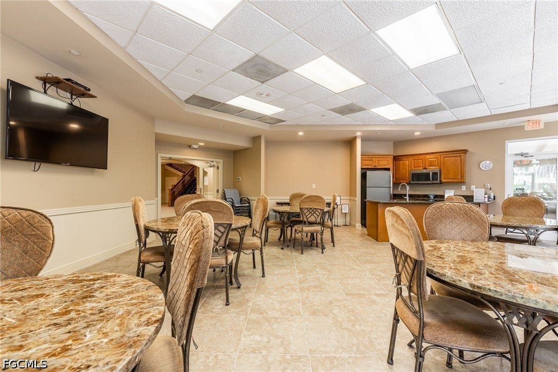 26600 ROSEWOOD POINTE Drive, #B-105, Bonita Springs, FL 34135 Dining room with baseboards, light tile patterned floors, and a paneled ceiling