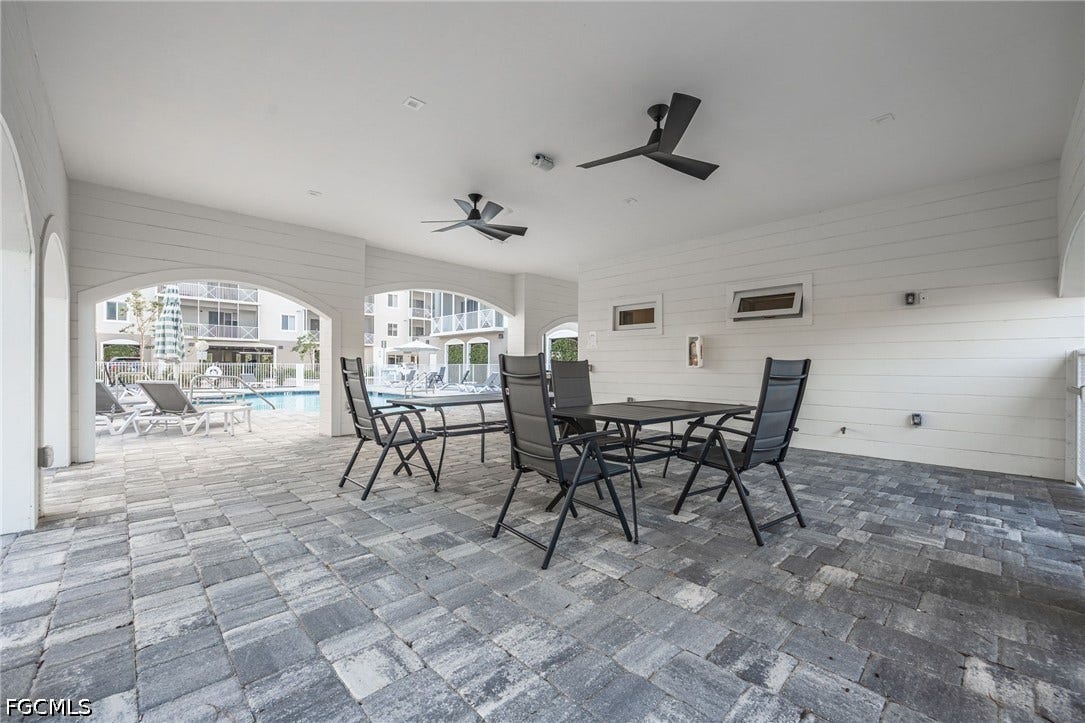 26600 ROSEWOOD POINTE Drive, #B-105, Bonita Springs, FL 34135 View of patio / terrace with outdoor dining area, a ceiling fan, and a community pool