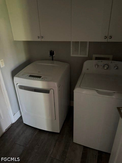 Laundry area featuring overhead cabinetry, wood-finish flooring, and light-toned walls