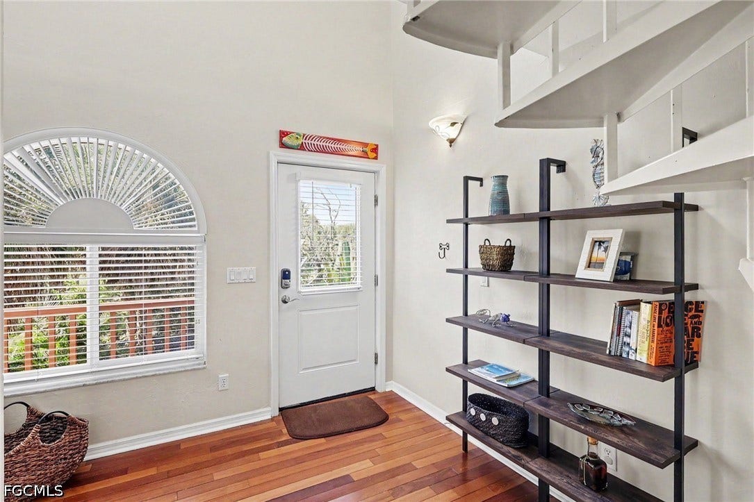 BLUE BAYOU B ENTRANCE.  WOOD FLOORING.  SUNBURST HALF MOON WITH WITH BLINDS.  IMPACT RESISTANT WINDOWS.