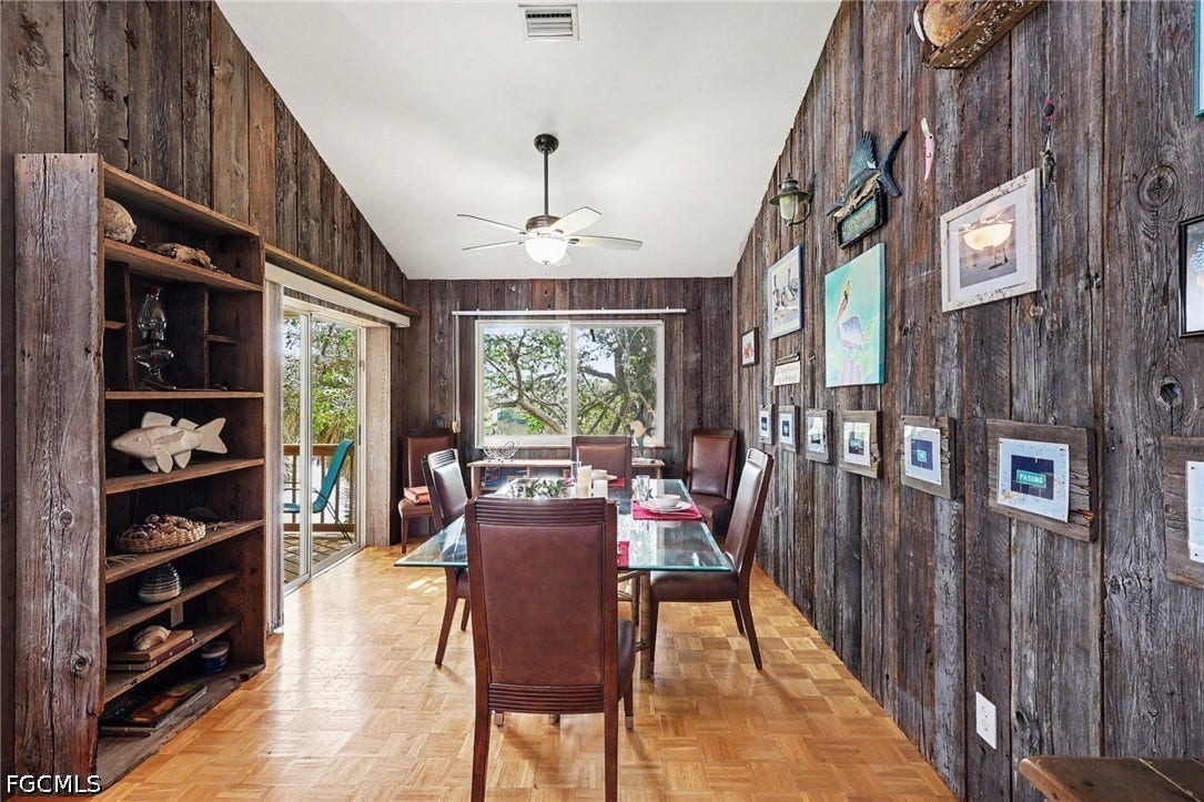 BLUE BAYOU A:  DINING AREA WITH EASTERN EXPOSURE WINDOW.  ENTRANCE TO COVERED DECK W/LAKE VIEWS IS SHOWN AT LEFT.  "BARN WOOD" STYLE WALLS.