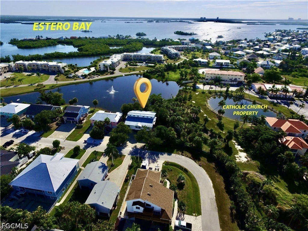 AERIAL VIEW OF LAKEFRONT COMMUNITY FEATURING MATURE LANDSCAPING, SERENE WATER FEATURES AND PROXIMITY TO ESTERO BAY