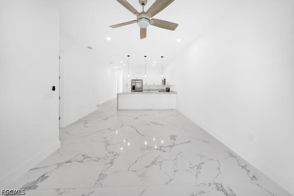 2416/2418 Joe Avenue S, Lehigh Acres, FL 33973 Spacious interior featuring large format tile flooring, recessed lighting, and a ceiling fan