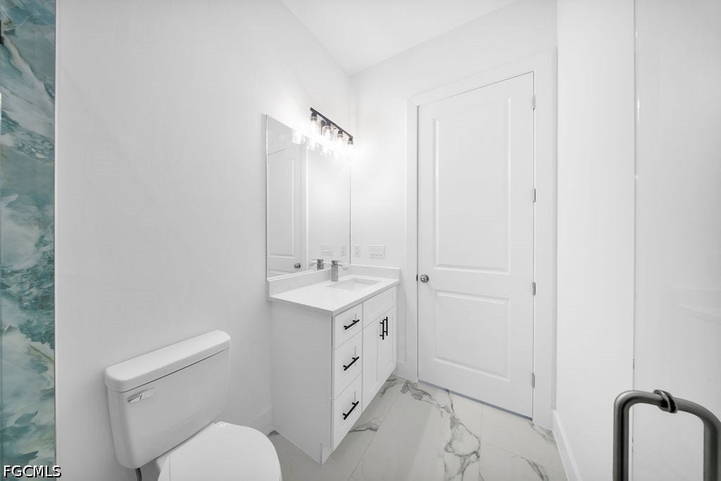 2416/2418 Joe Avenue S, Lehigh Acres, FL 33973 White vanity with black hardware, integrated sink, and white countertop