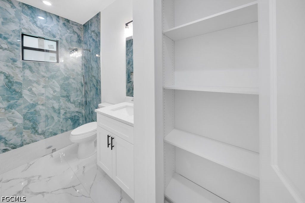 2416/2418 Joe Avenue S, Lehigh Acres, FL 33973 Bathroom with a white vanity, integrated sink, and black hardware
