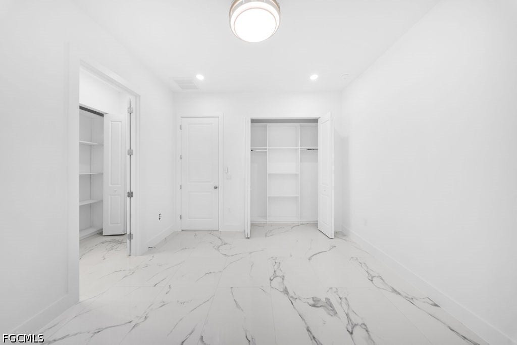 2416/2418 Joe Avenue S, Lehigh Acres, FL 33973 Tile flooring, recessed lighting, ceiling light fixture, built-in shelving, and white interior doors