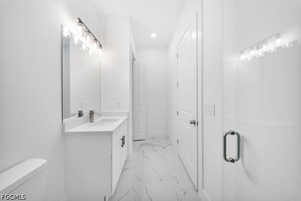 2416/2418 Joe Avenue S, Lehigh Acres, FL 33973 White vanity with an integrated sink, polished chrome faucet, and black hardware